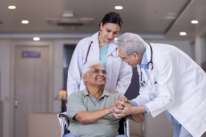Doctors supporting an elderly patient